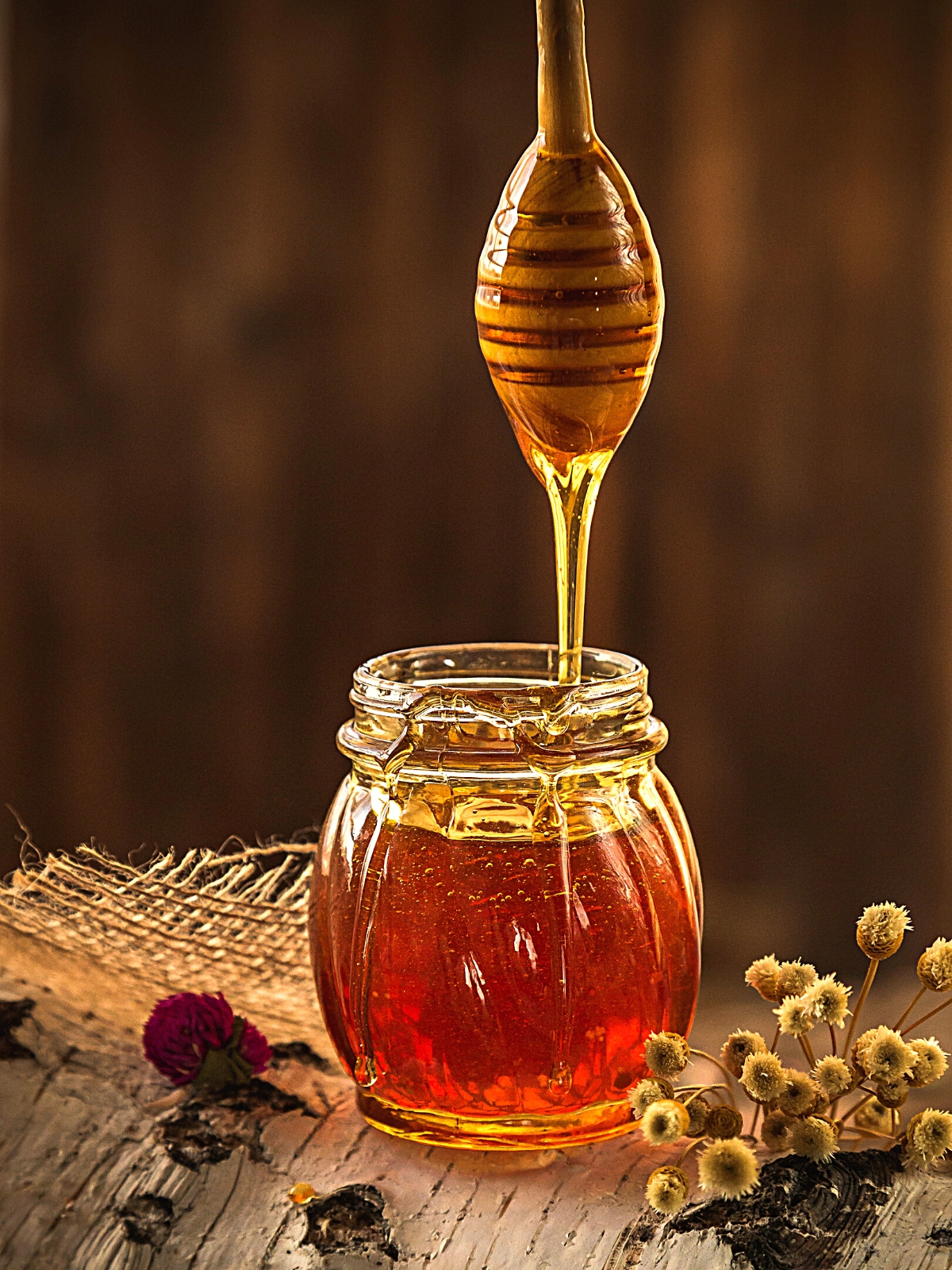 A glass Jar of Honey on Wooden Background