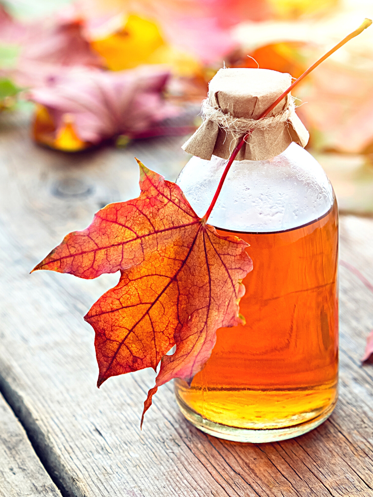 A Glass Bottle of Maple Syrup, with a maple leaf around it.