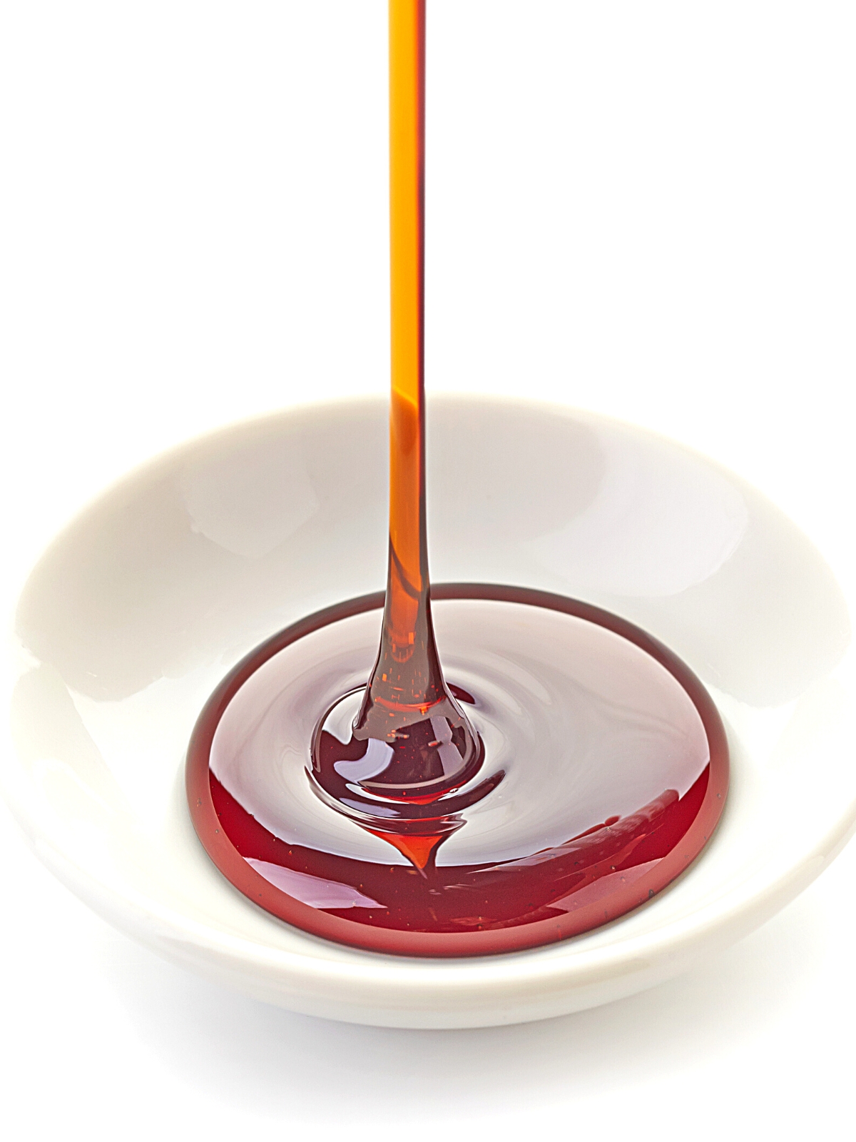 brown sugar syrup dripping into a white bowl.