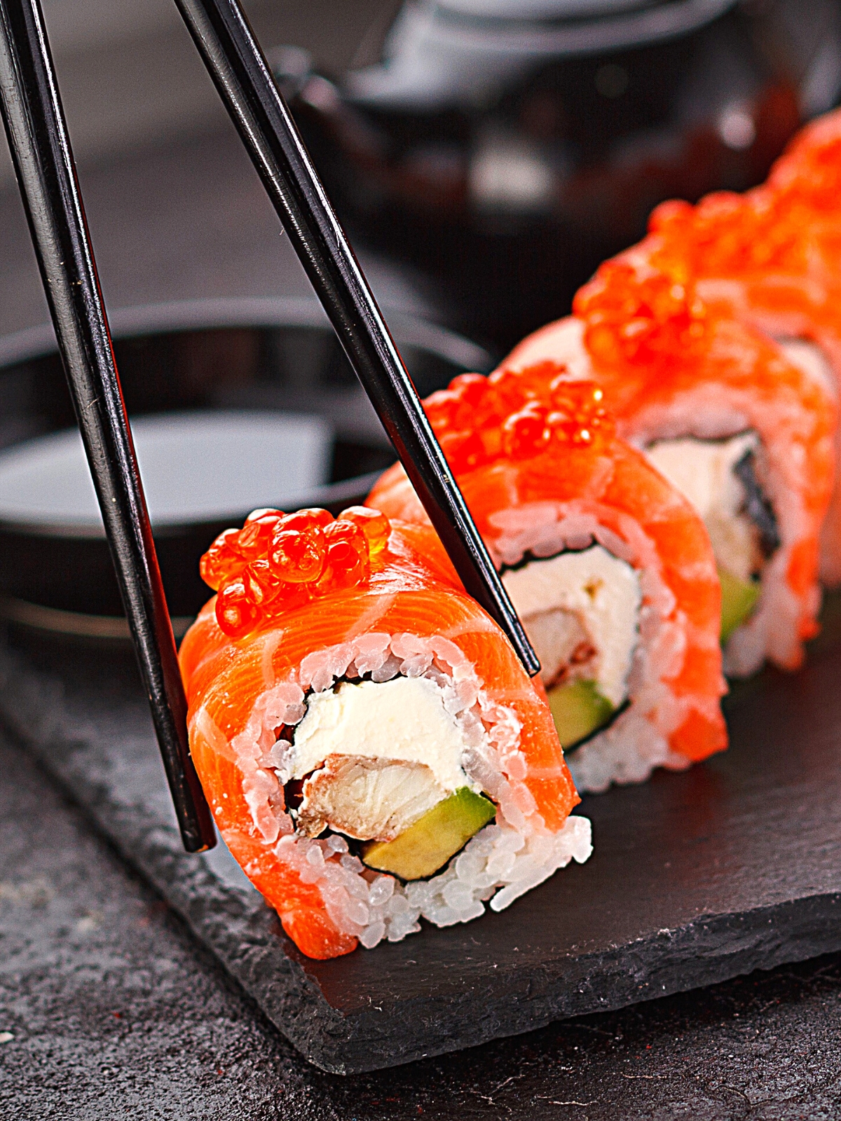 Sushi Roll being lifted using a chopstick.