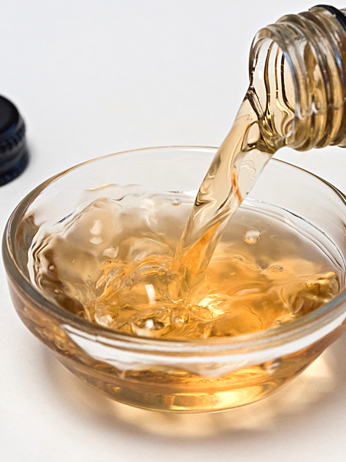 Pouring of sherry vinegar in a glass bowl.