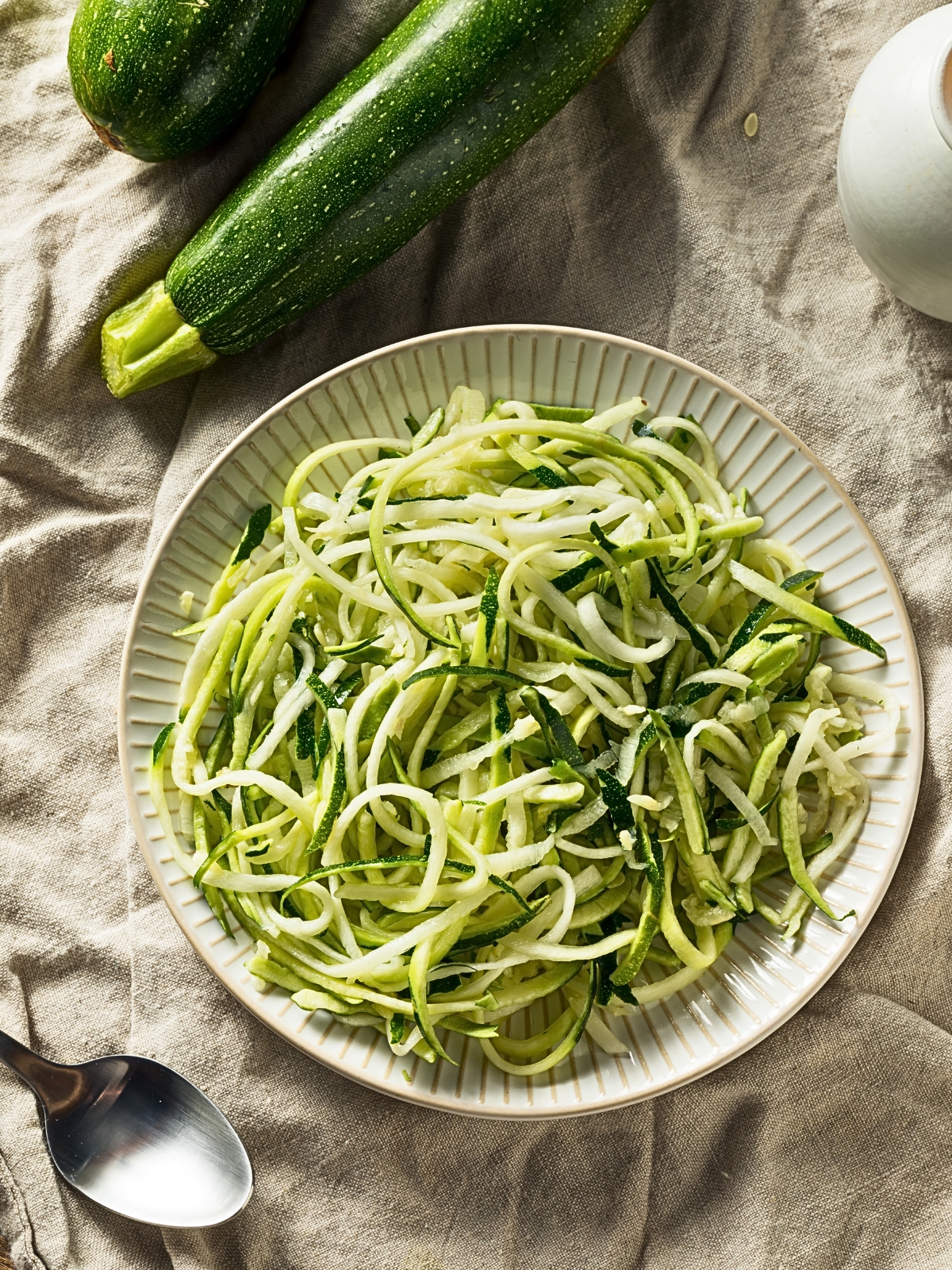 A plate of Raw Green Organic Zucchini Noodles Zoodles.