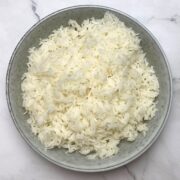Grey bowl filled with cooked white rice.