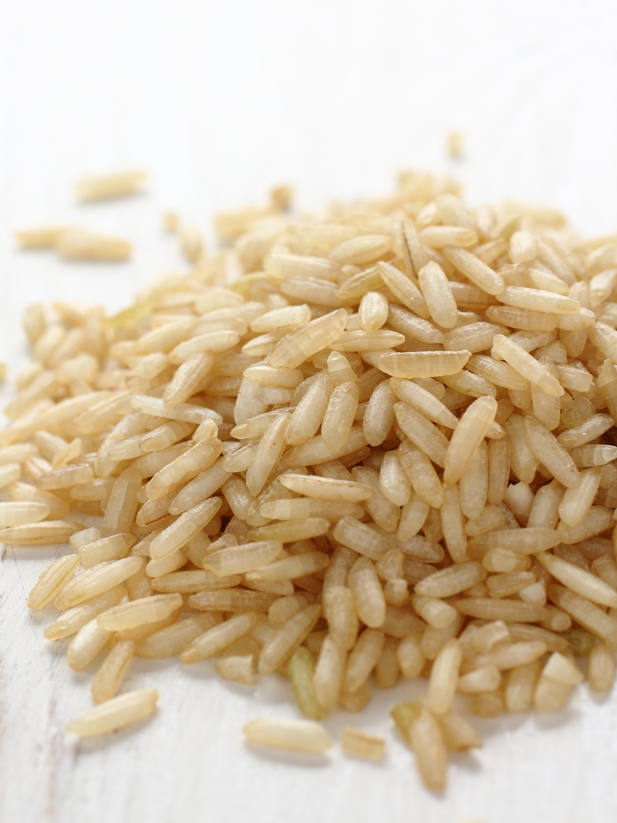 Pile of Brown Rice Grain on a white surface.