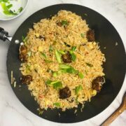 Black pepper crispy chicken fried rice in a wok.