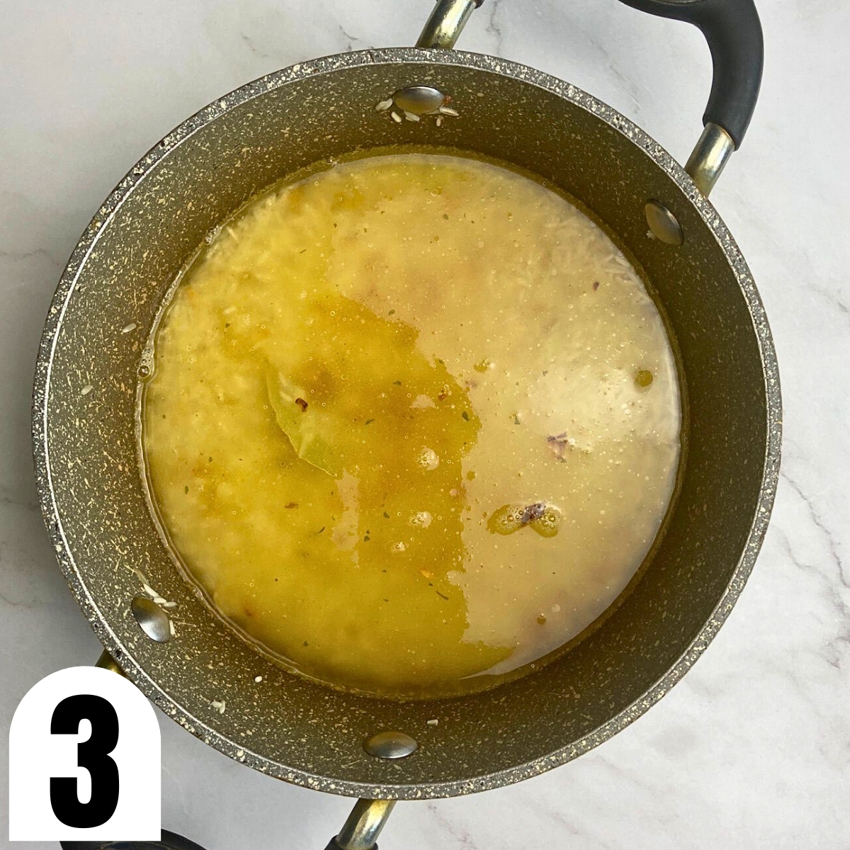 Broth and rice in saucepan.