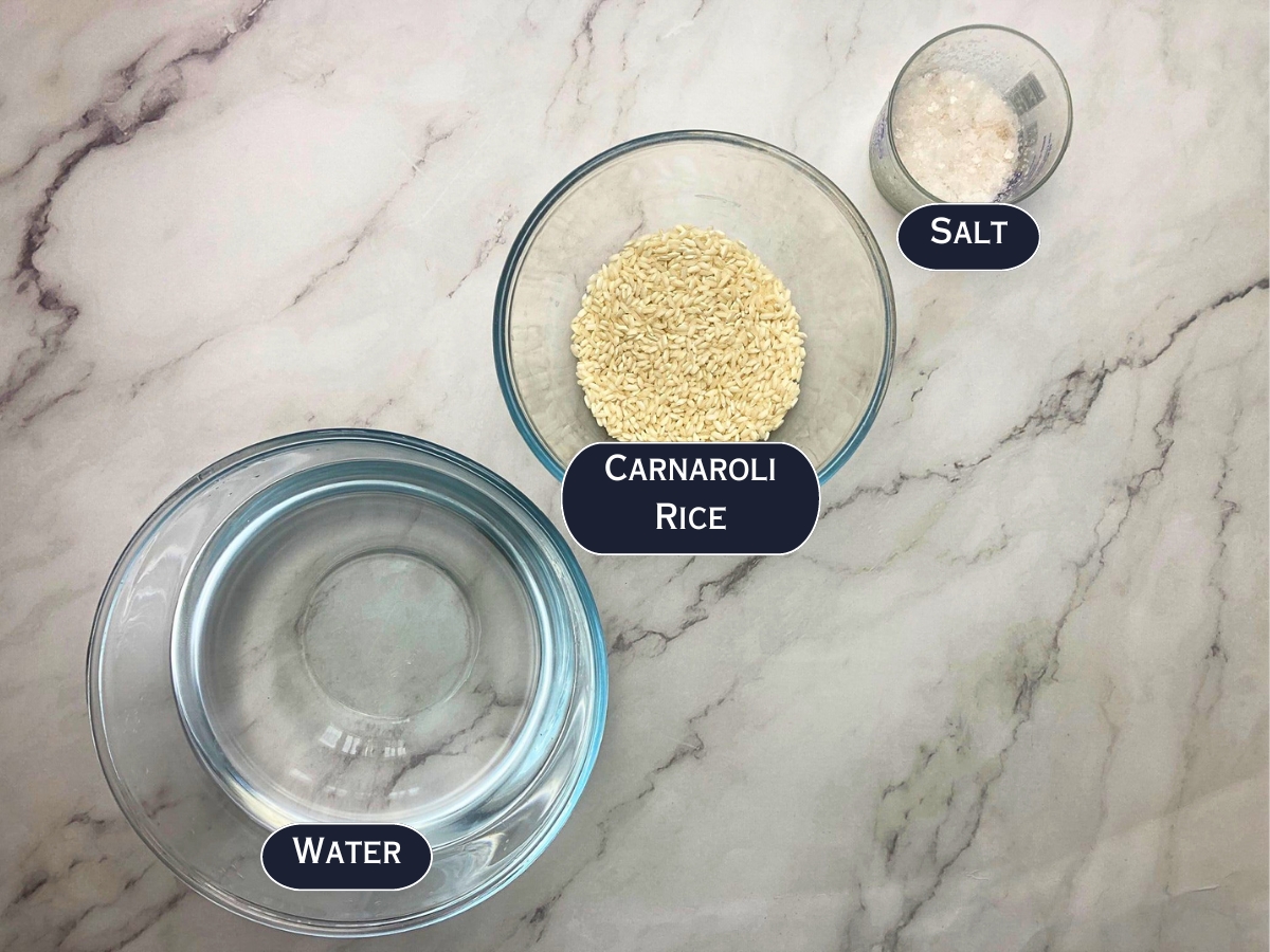 Ingredients needed to boil Carnaroli rice displayed on a marble countertop.