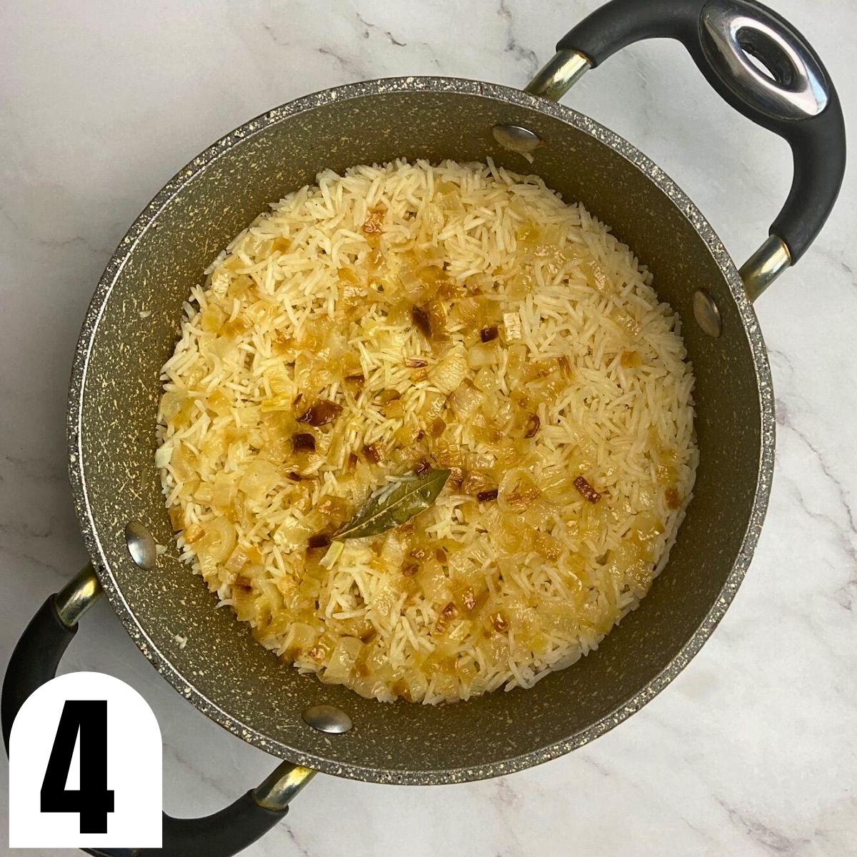 Onion and rice cooked in saucepan.