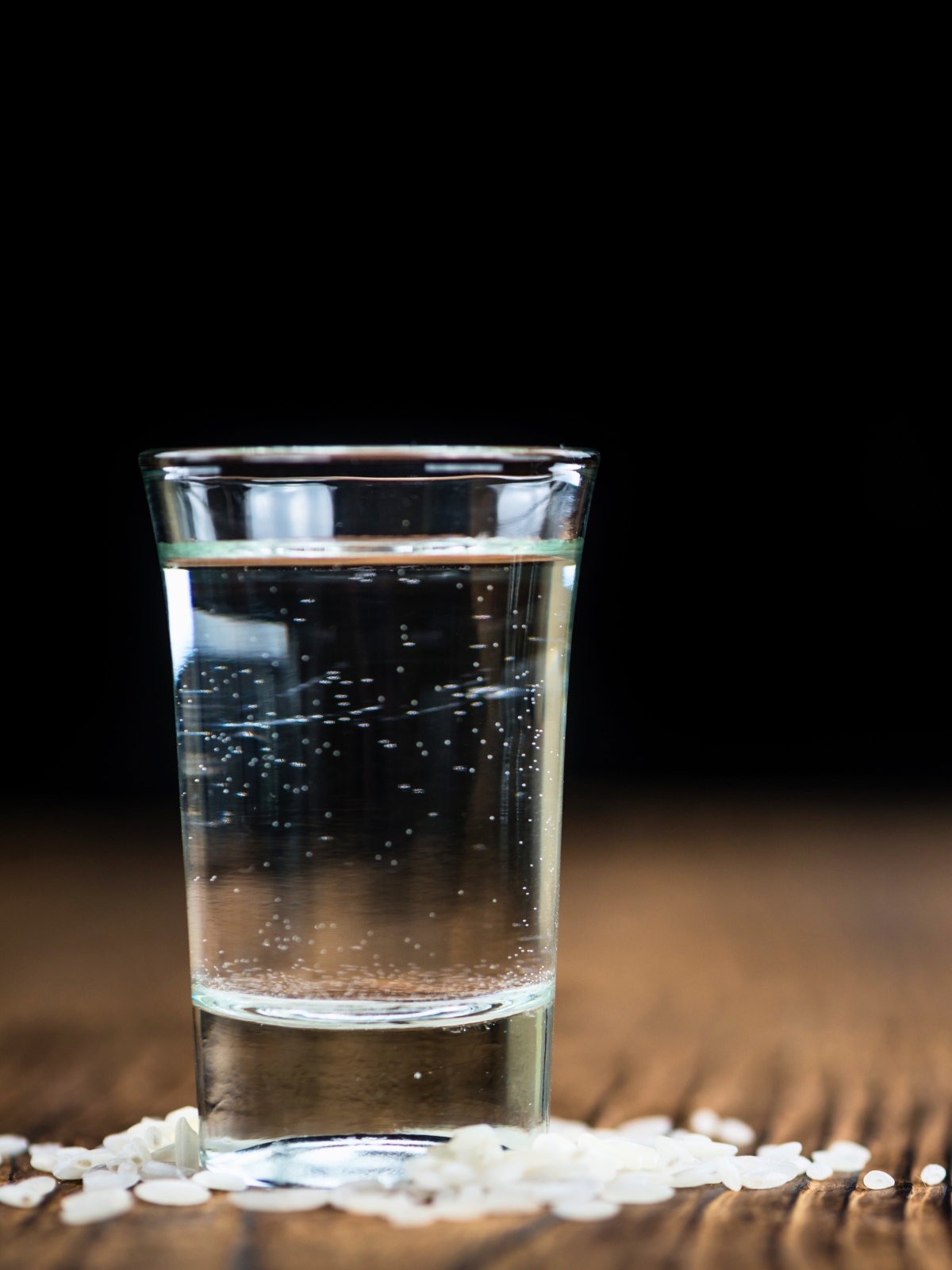 Shot glass with clear homemade sake.