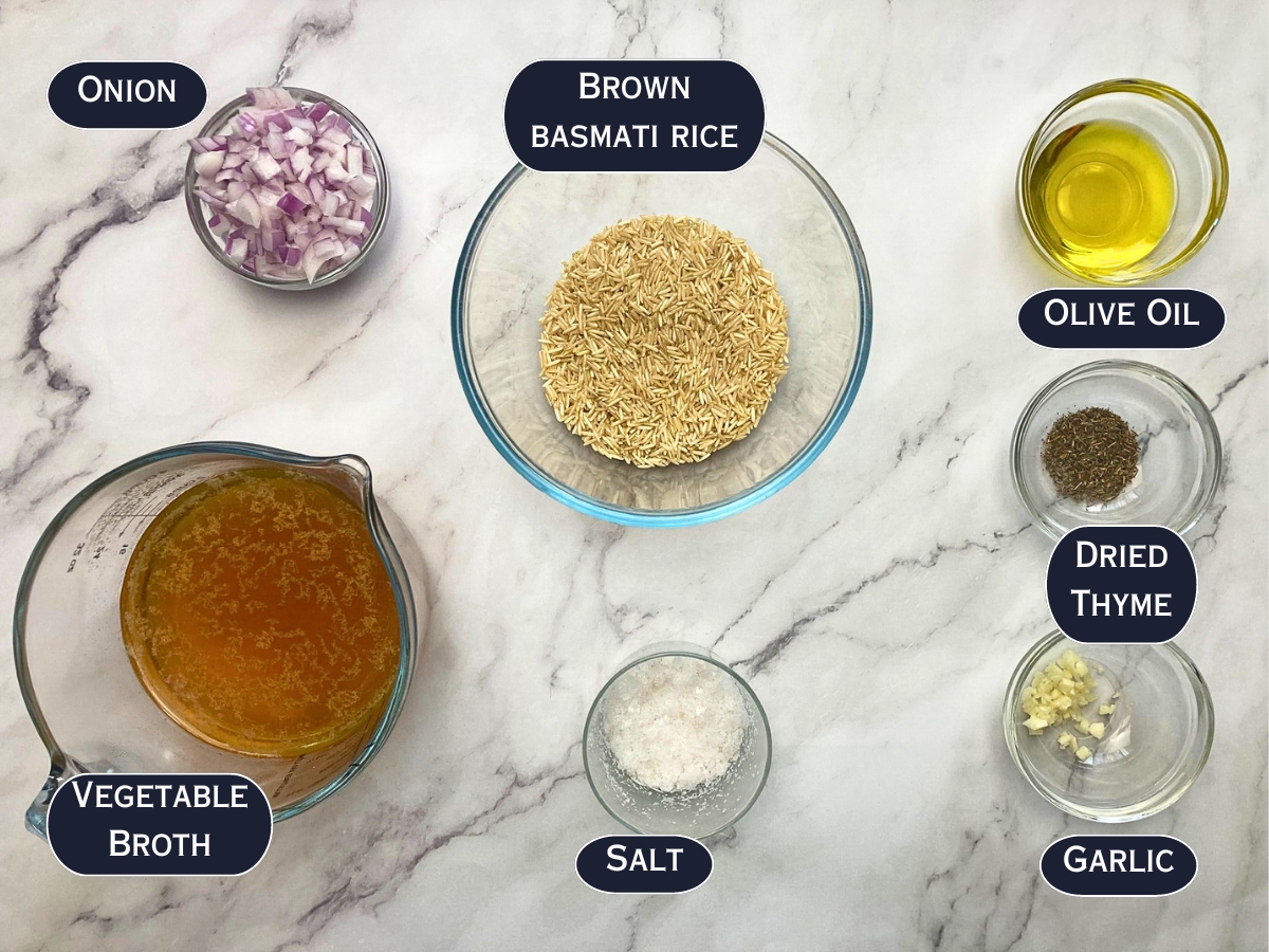 Ingredients for brown rice pilaf displayed on a marble countertop.