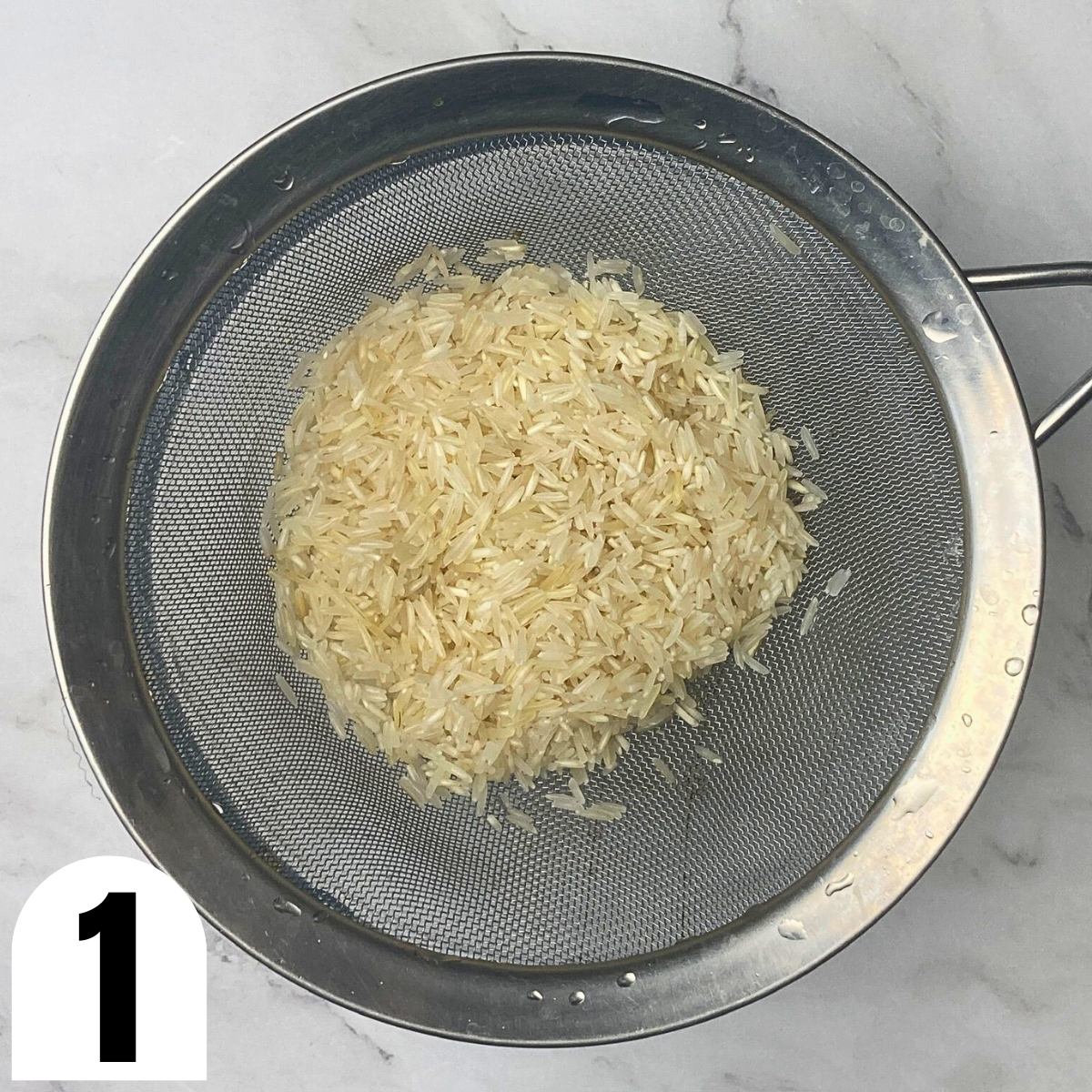 Rinsed basmati rice in a fine mesh sieve.