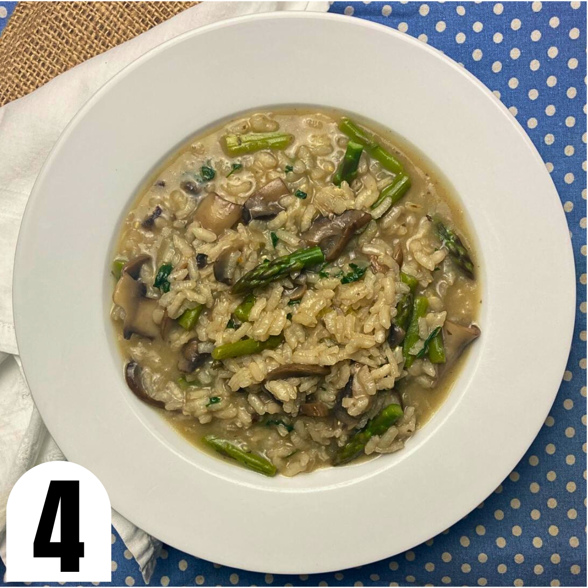 White plate with mushroom and asparagus risotto on top of a blue and white tea towel.