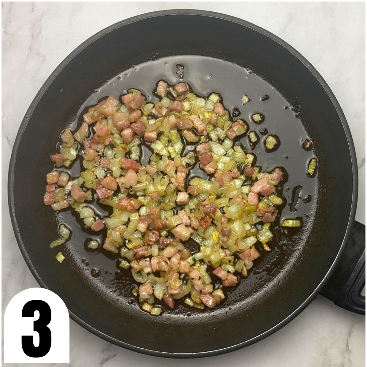 Frying pan with sauteed chopped onions and pancetta.